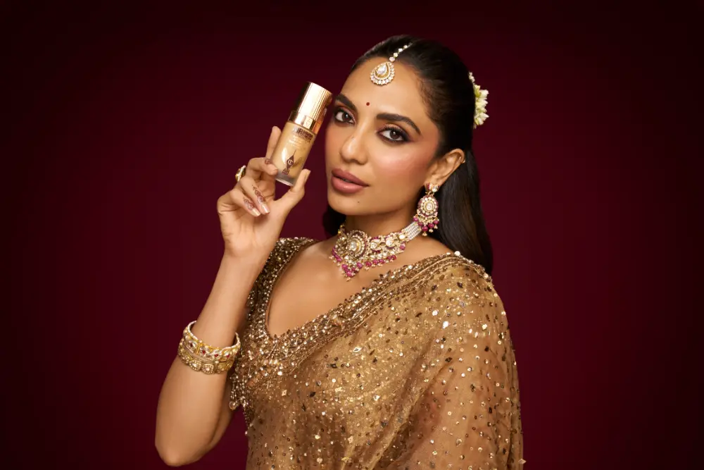 Sobhita with a Charlotte Tilbury product