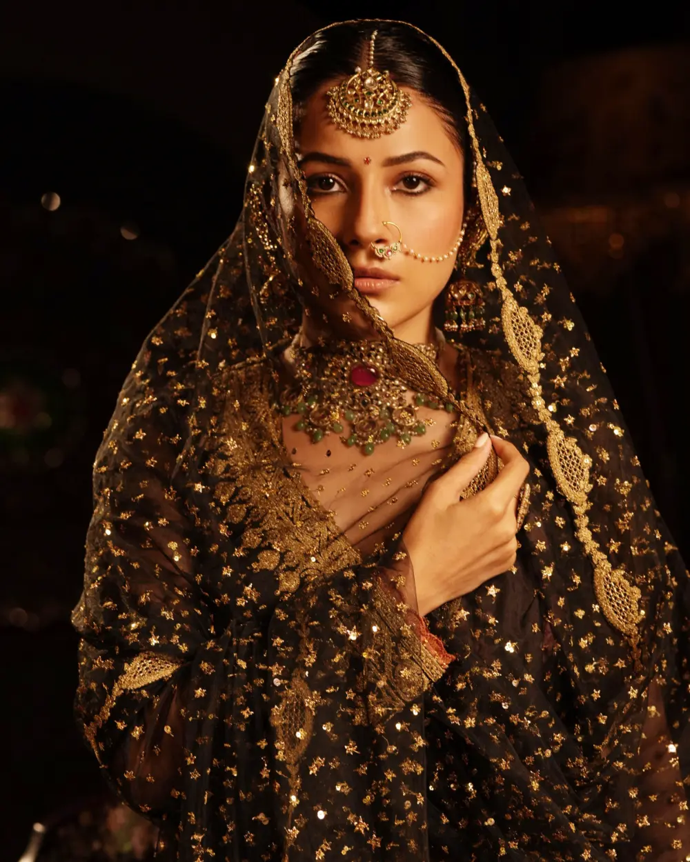 The drama of the inky blue outfit contrasts with the jewels with emeralds and polki